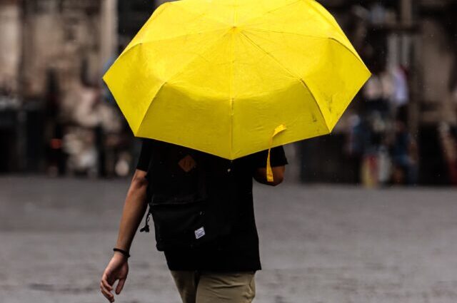 Persona con ombrello nel centro storico di Catania